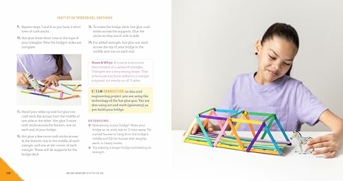 Child constructing a bridge model with colored sticks.