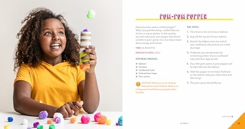 Child holding a DIY pom-pom popper made from a cardboard tube and balloons, with colorful pom-poms on the table.