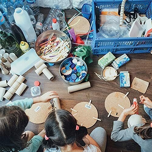 Children crafting with recycled materials on a wooden floor.