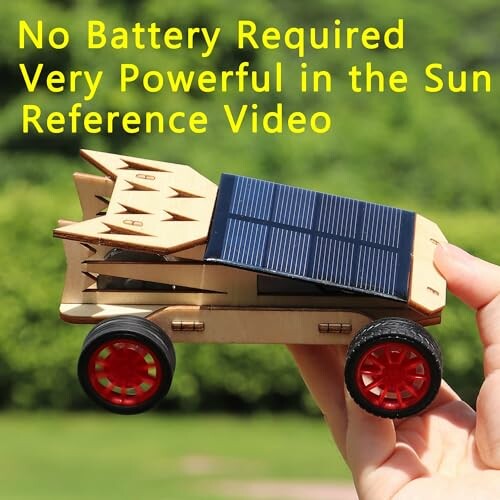 Hand holding a solar-powered toy car with red wheels.